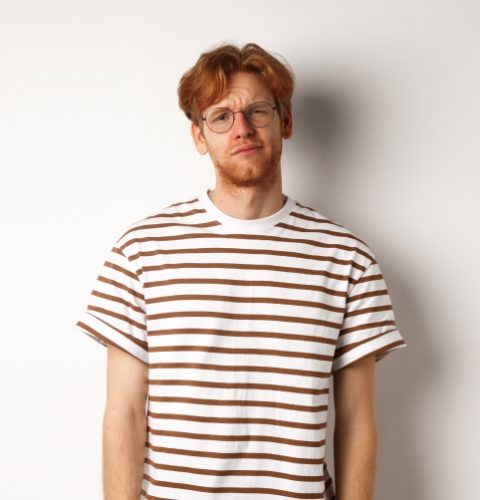 reluctant-and-unamused-redhead-young-man-staring-a-2ZK43U3.jpg